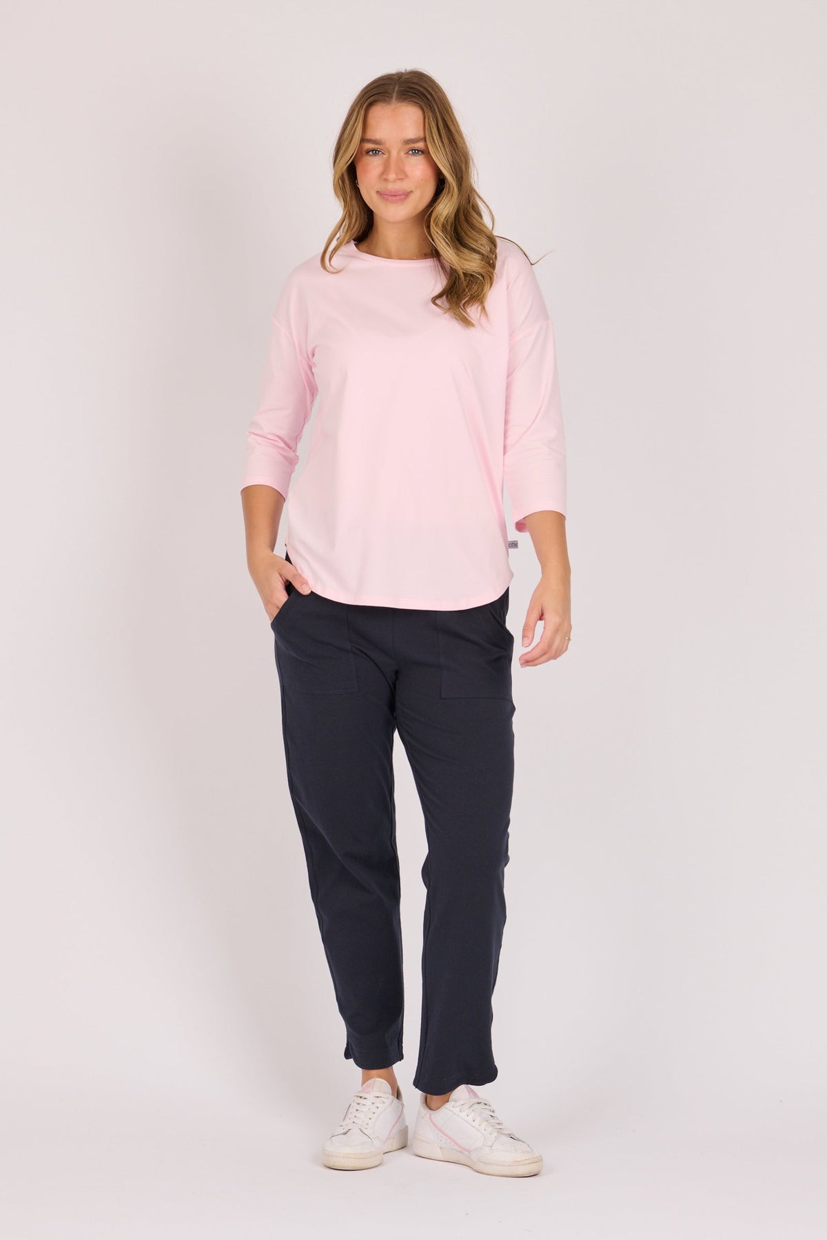 One Ten Willow Scoop Hem Top in pink, full length styled with navy pants